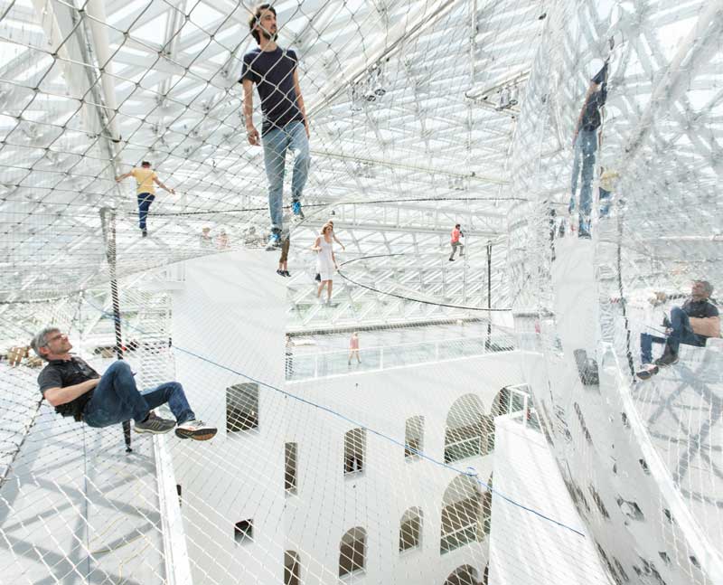 In mehr als 20 Metern Höhe bewegen sich Besucher spinnengleich in der Sicherheitsnetz-Landschaft des Künstlers und Architekten Tomás Saraceno. (Foto: Studio Tomás Saraceno)