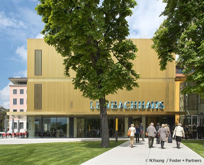 An der Fassade Reihen goldener Metallröhren, drinnen eine Streifen an die Wand werfende Installation von Olafur Eliasson: das Lenbachhaus in München ist nicht nur ob der beherbergten Sammlung sehenswert. (Foto: N. Young / Foster + Partners)