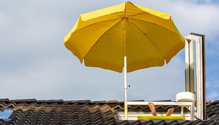 Geöffnetes Dachfenster mit Sonnenschirm