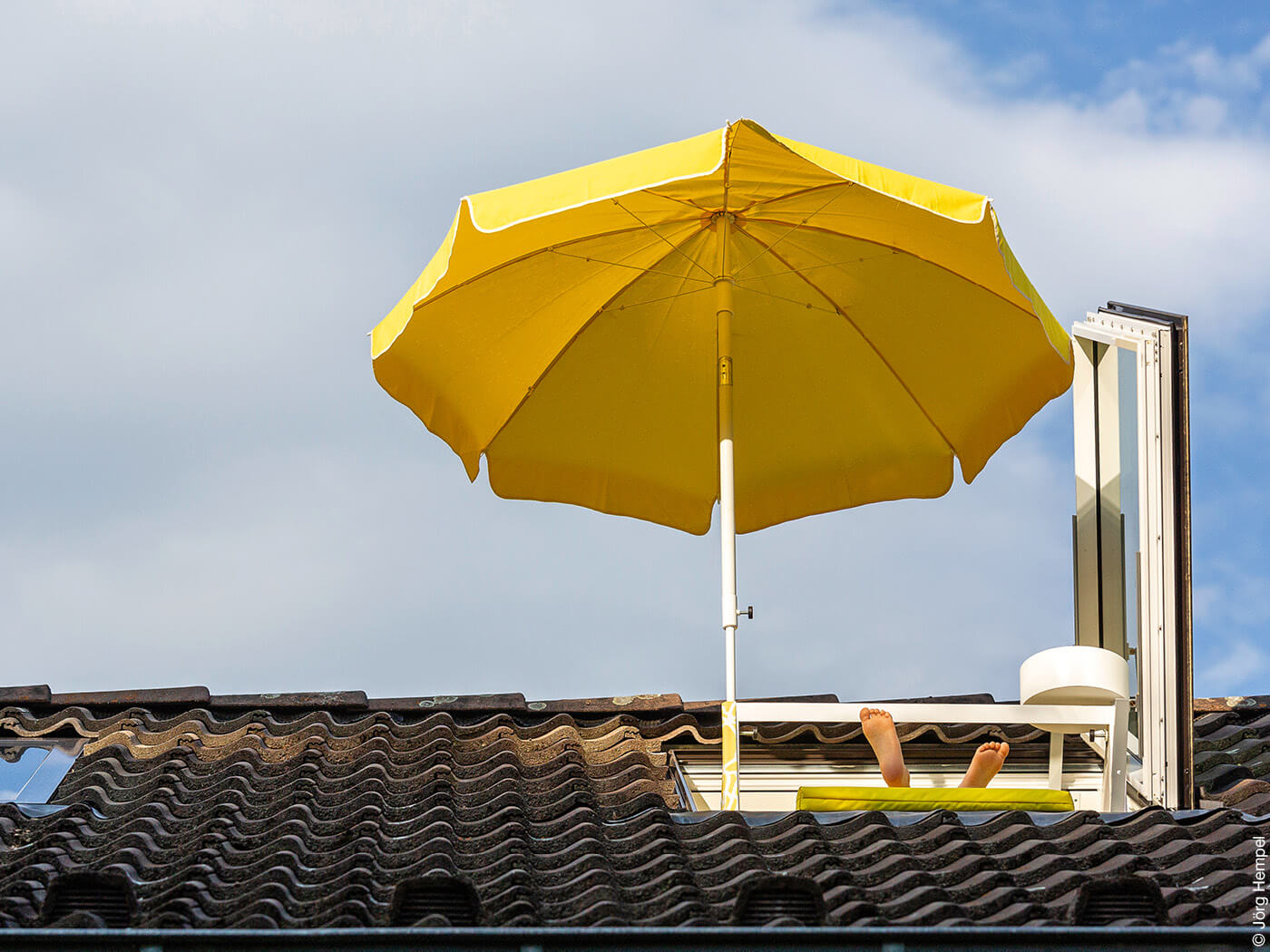 Geöffnetes Dachfenster mit Sonnenschirm