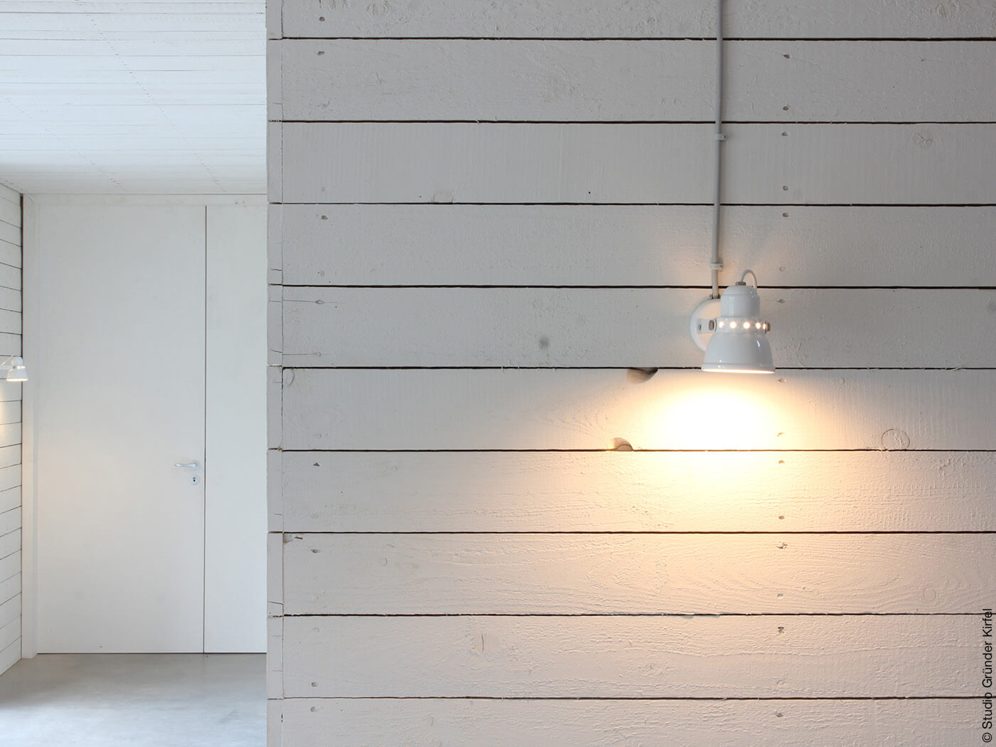 weiße Wand aus Holz mit Lampe