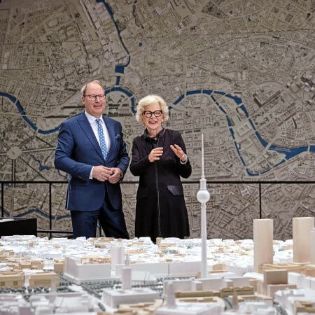 Mann und Frau stehen hinter Modellbau von Berlin