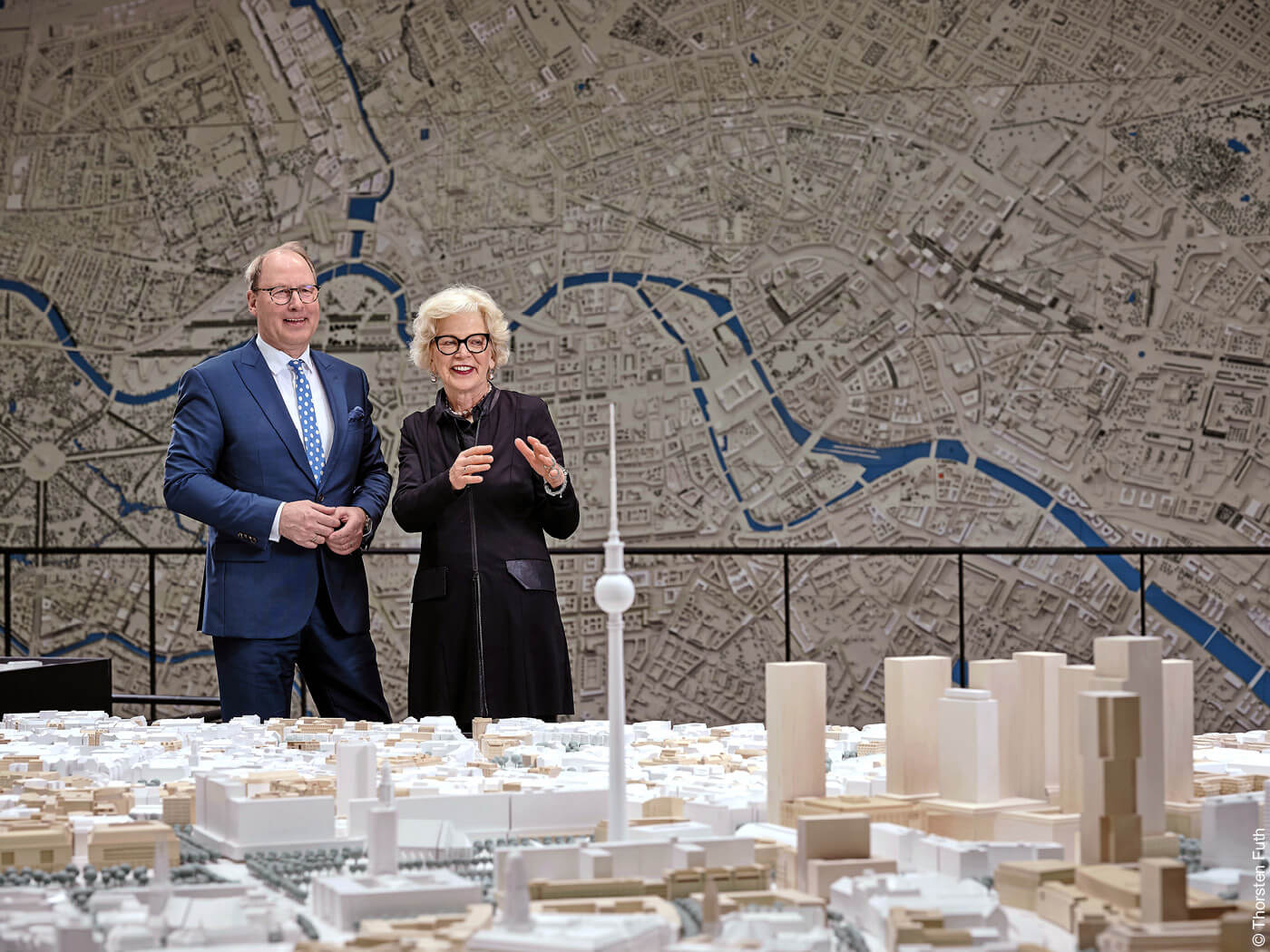 Mann und Frau stehen hinter Stadtmodell von Berlin