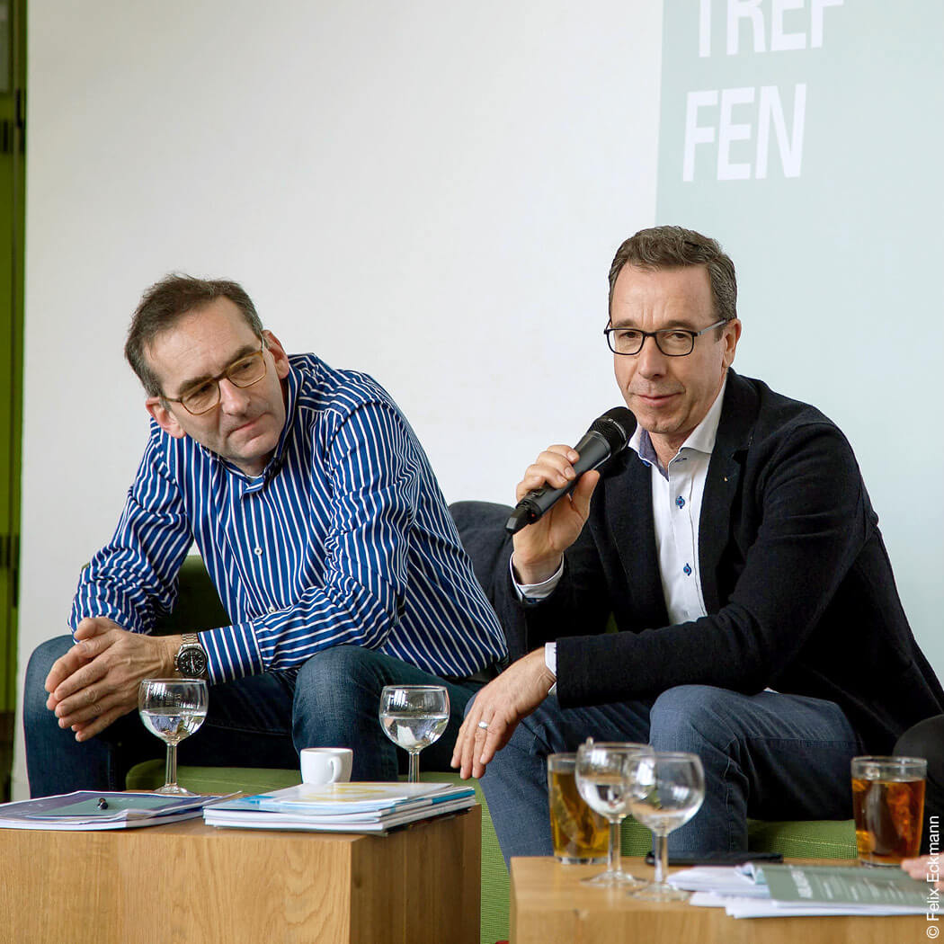 Zwei Männer bei einer Podiumsdiskussion