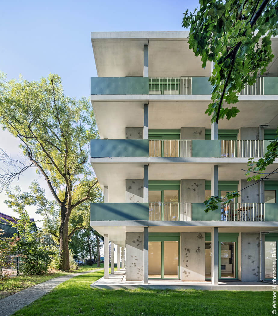 Außenansicht auf das Wohngebäude mit Blättern in der Fassade