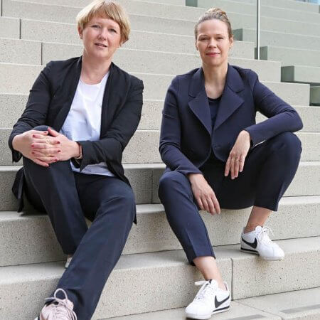 Barbara Eitner und Birte Riepenhausen von null2elf sitzen auf einer Treppe