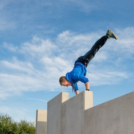 Mann turnt auf einer Mauer