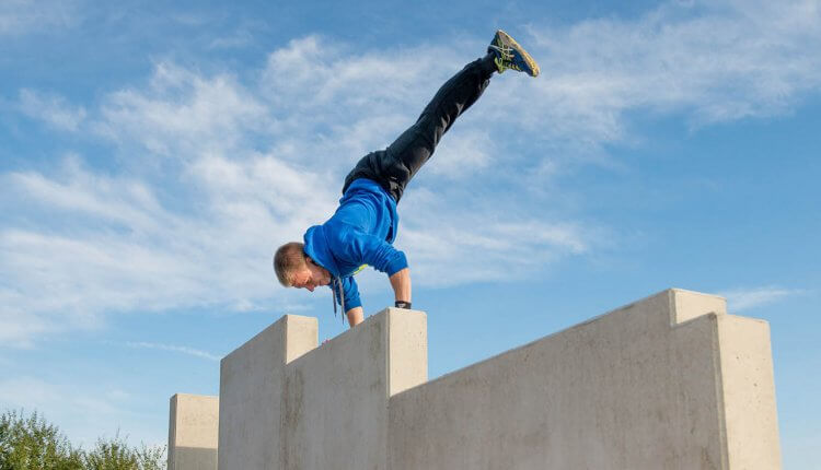 Mann turnt auf einer Mauer