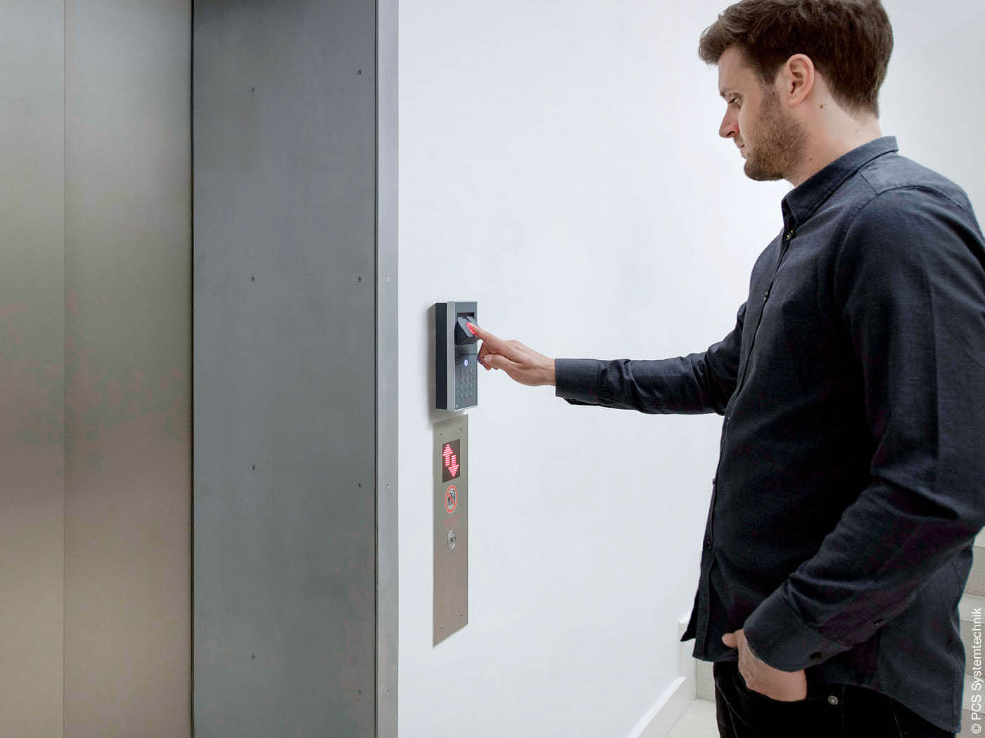 Mann identifiziert sich am Aufzug mit seinem Fingerabdruck