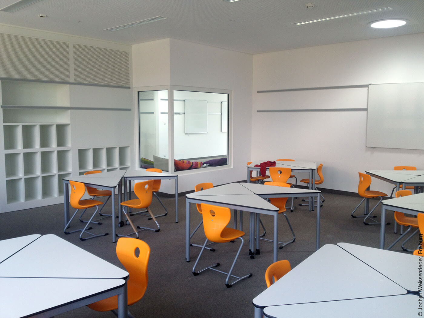 Klassenzimmer mit orangenen Stühlen
