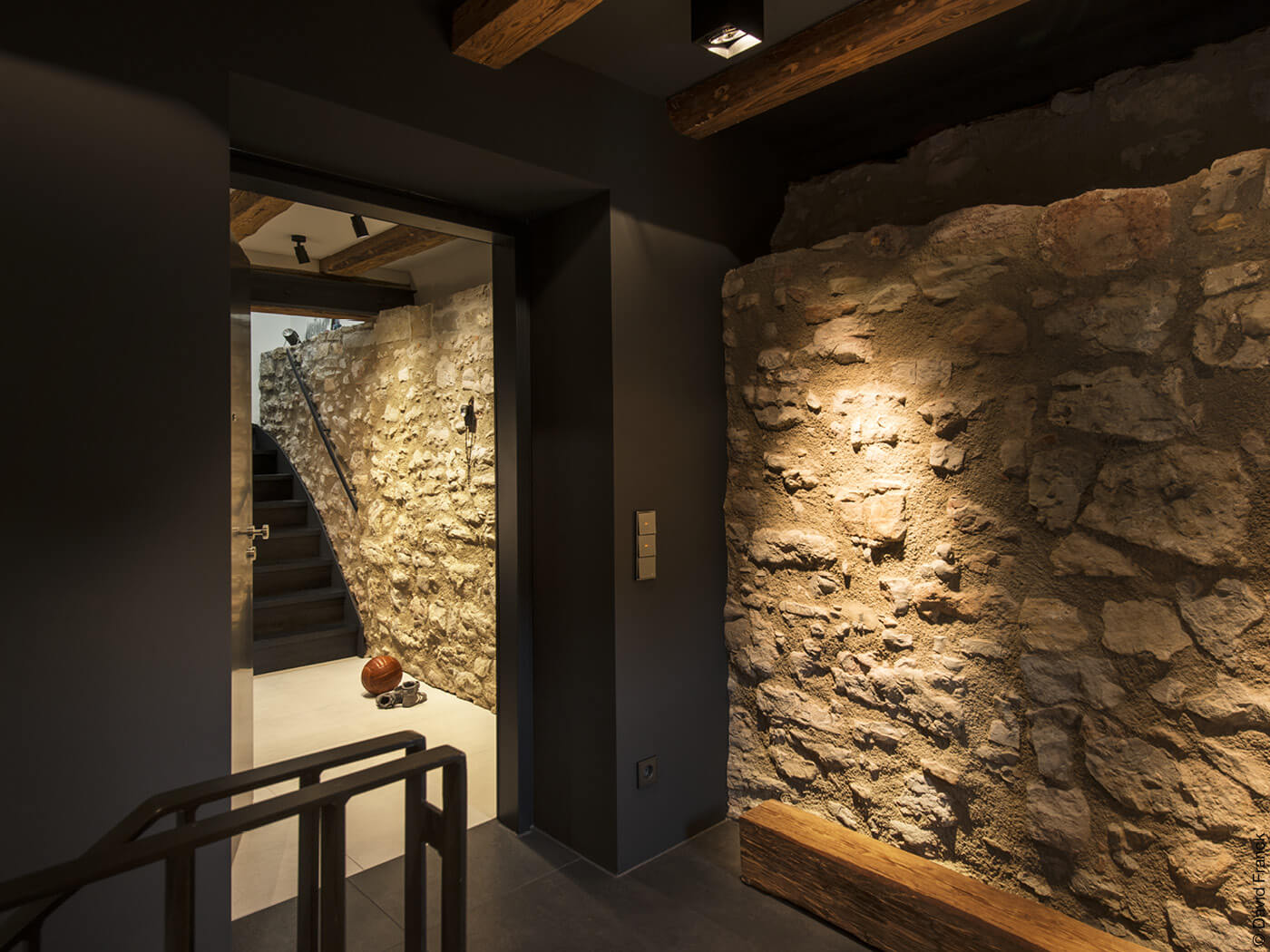 Innenraum mit Steinwänden und schwarz verkleideten Wänden