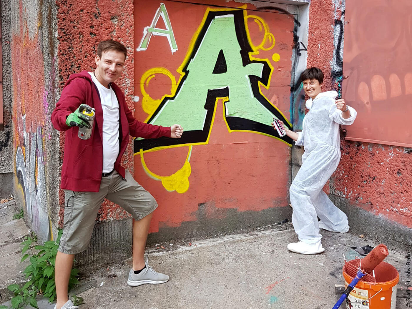 Zwei Personen bemalen Hauswand