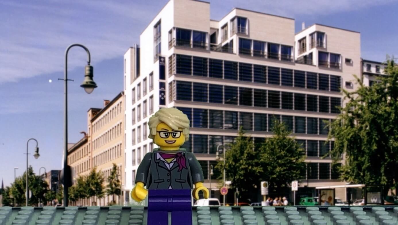 Legofigur vor Bürohaus