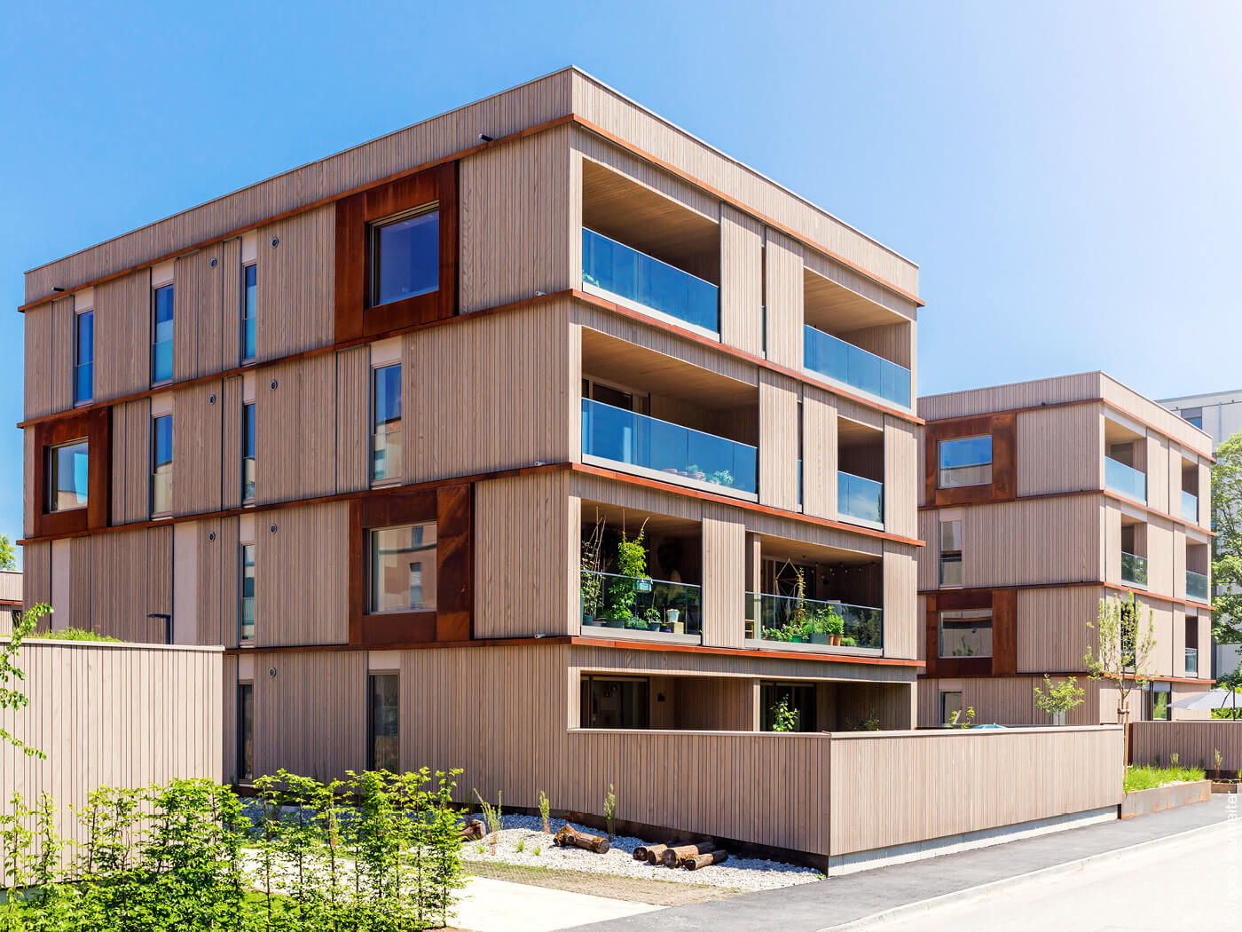 Wohnhaus mit Holzfassade und verglasten Balkonen