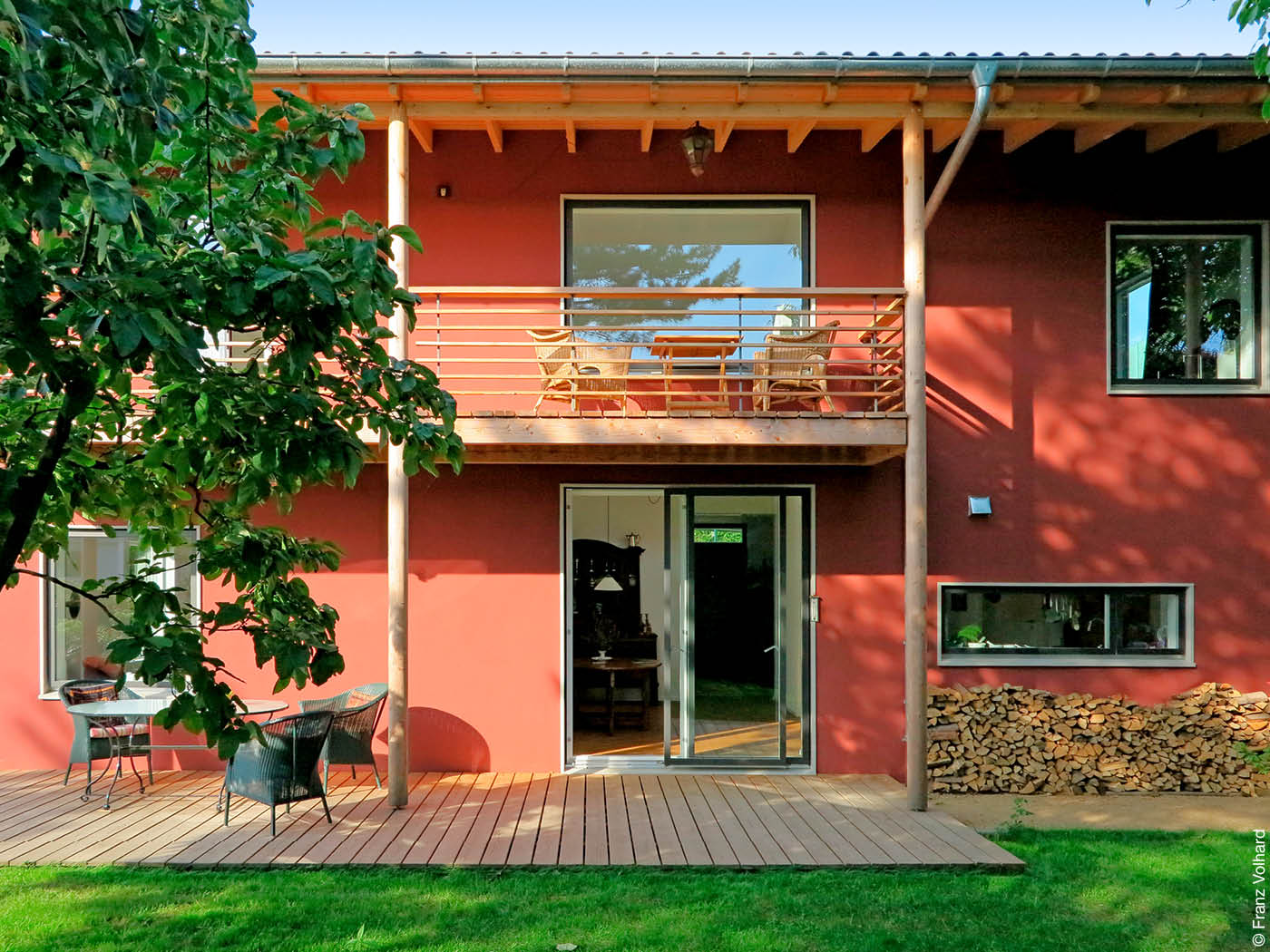 Wohnhaus mit Terrasse und Balkon und roter Fassade