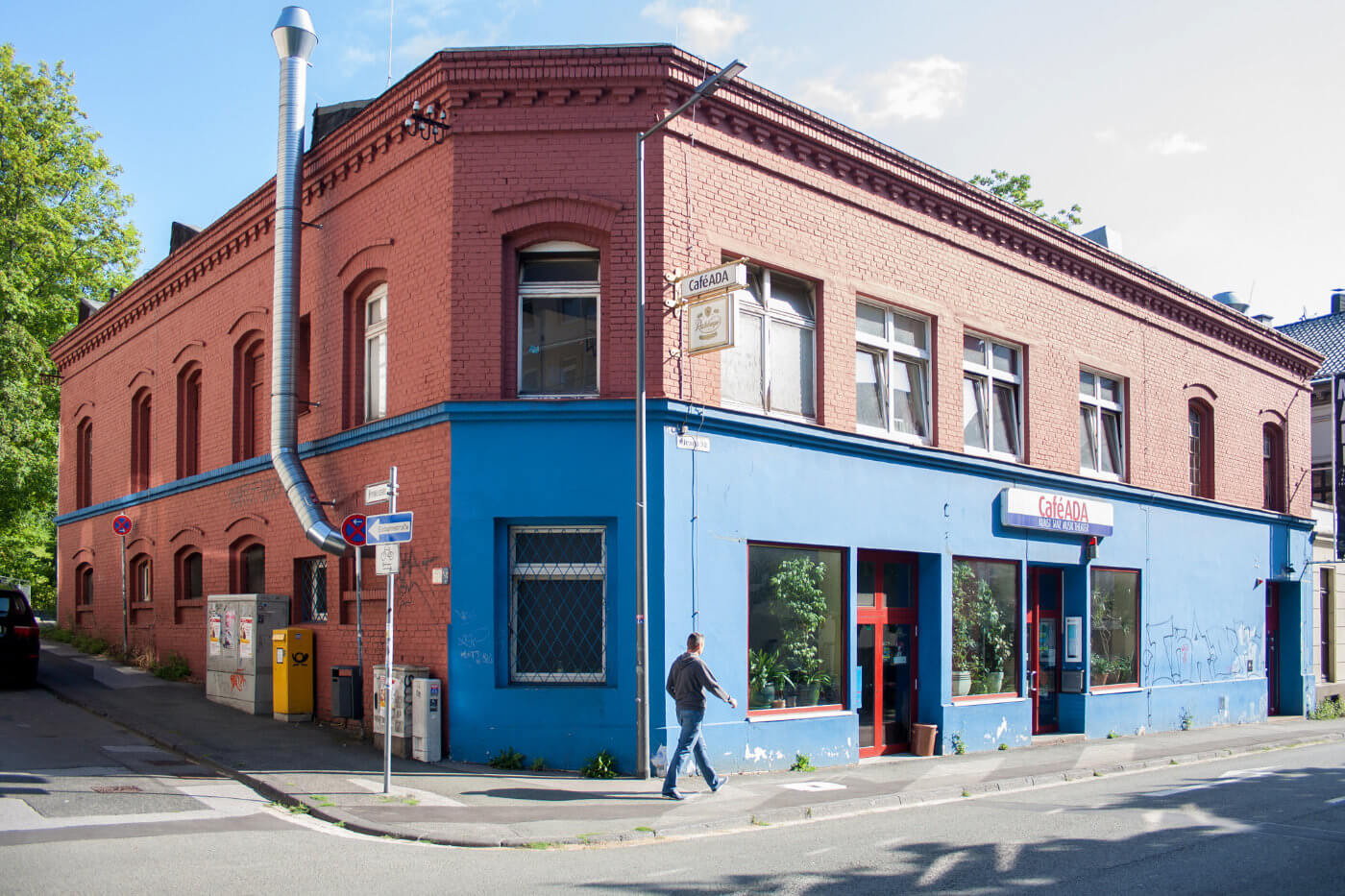 zweigeschossiger Altbau mit Backstein und blauer Fassade