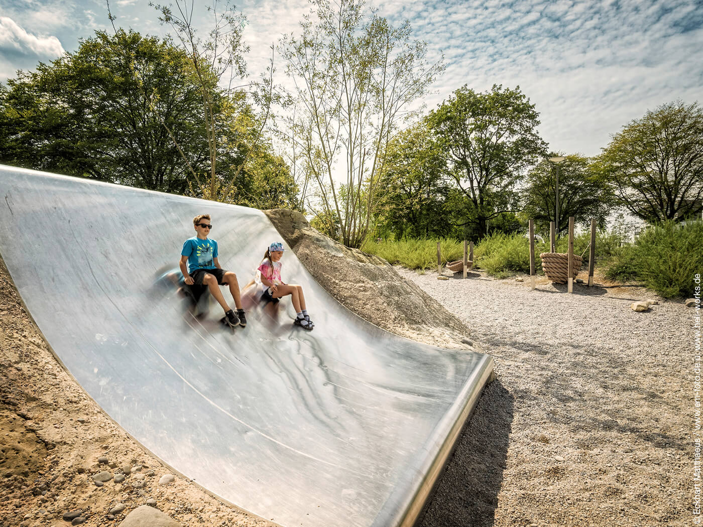 Kinder rutschen auf dem Spielplatz im Augsburger Westpark