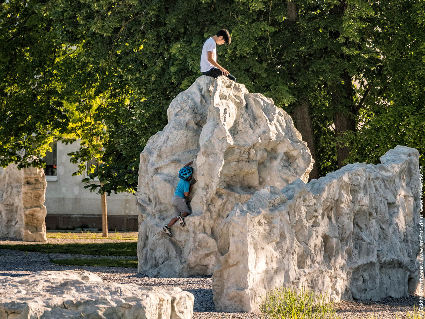 Kinder klettern auf Steinen im Augsburger Westpark
