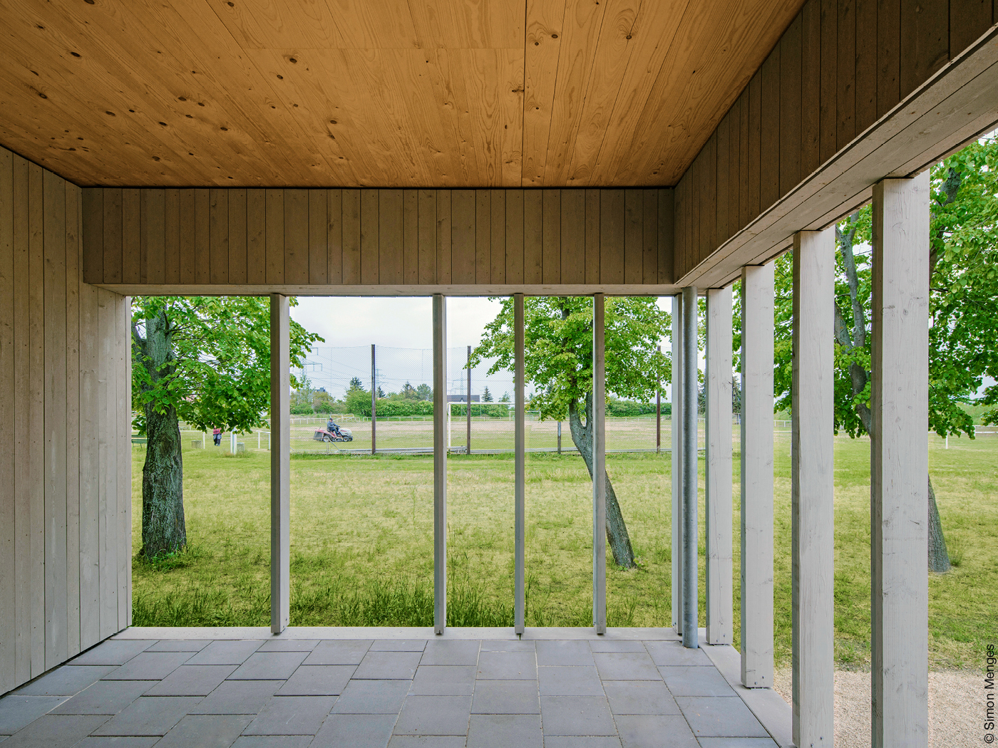 Eingangsloggia aus Holz öffnet sich zum Fußballplatz