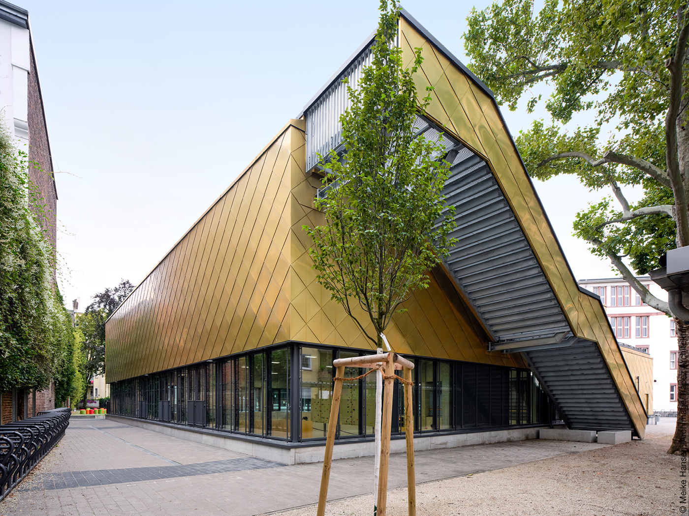 Sporthalle mit goldener Fassade und Treppe