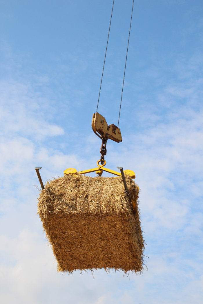 Strohballen an Kran hängend