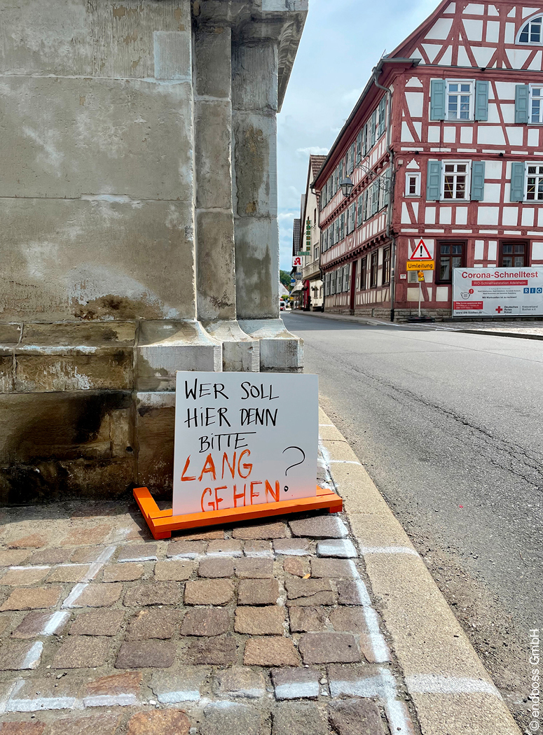 Plakat einer Bürgerbeteiligung mit Aufschrift "Wer soll hier denn bitte lang gehen" an schmalem Bürgersteig