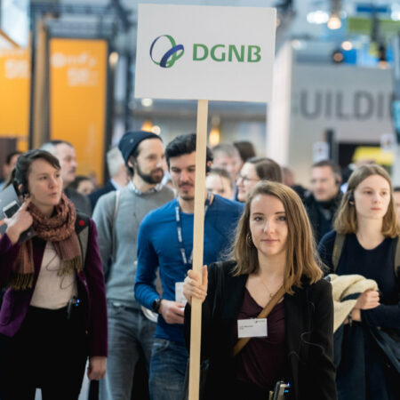 Junge Besuchergruppe auf eine Messe mit Schild der DGNB