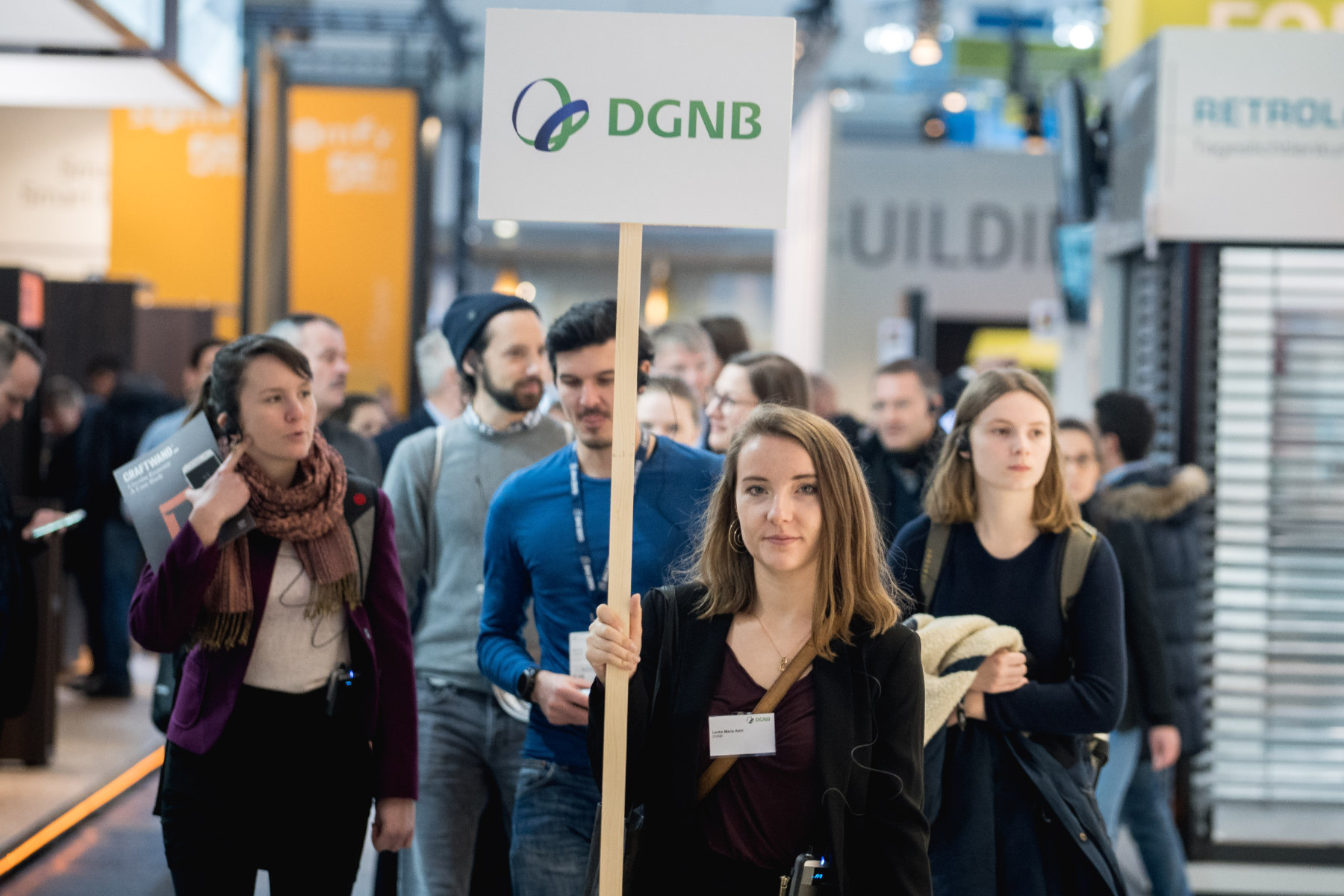 Junge Besuchergruppe auf eine Messe mit Schild der DGNB