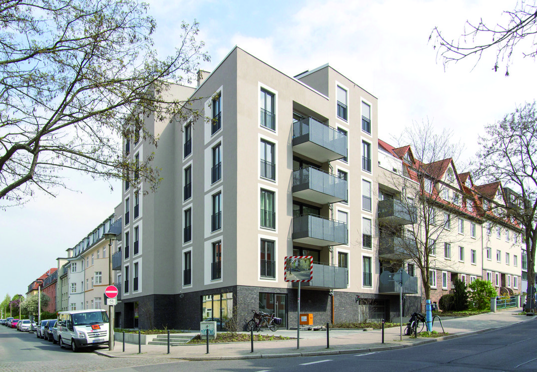 Mehrfamilienhaus mit Balkonen an Straßenecke