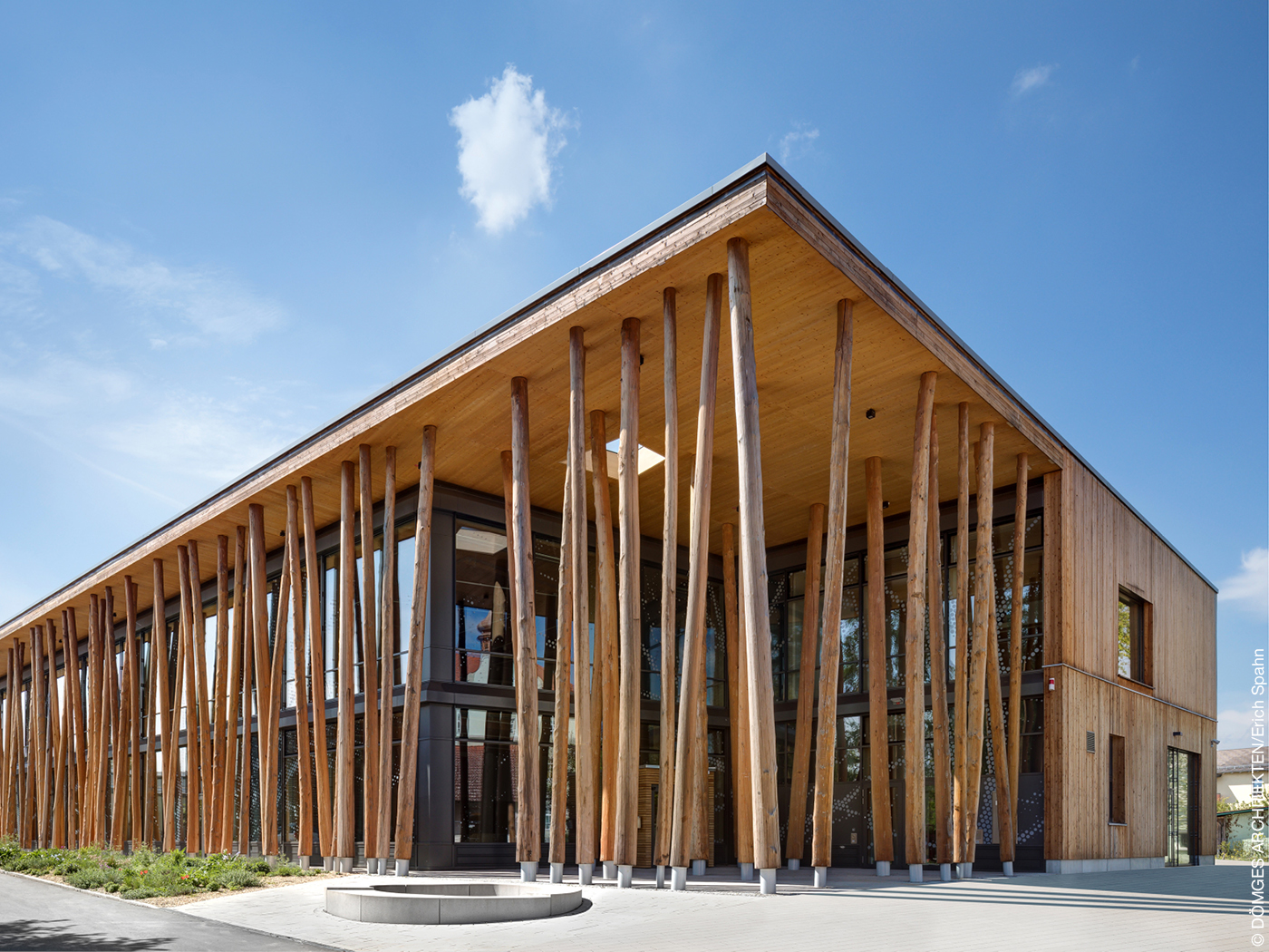 Baumstämme an einem Holzbau tragen ein Vordach