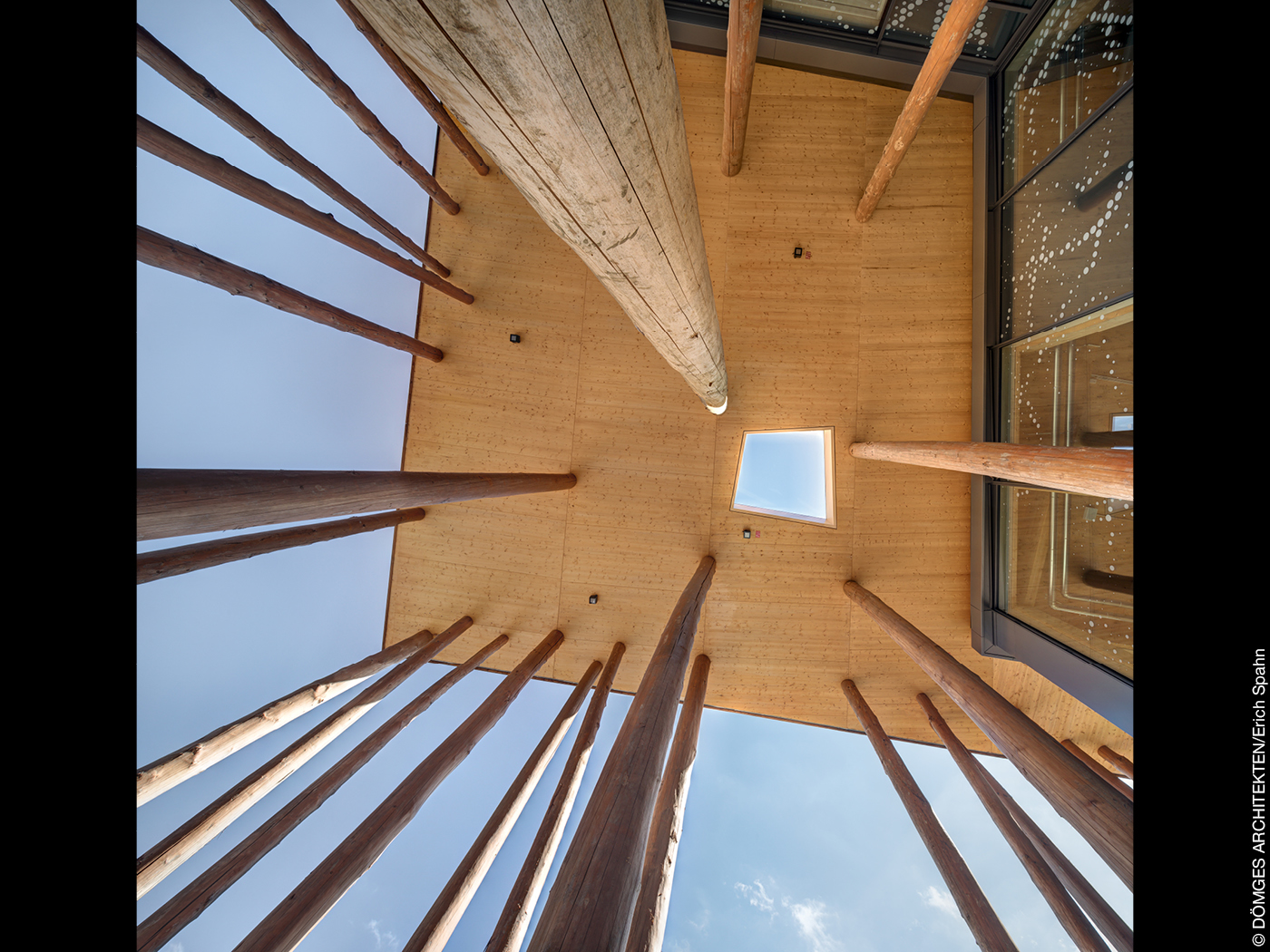 Baumstämme an einem Holzbau tragen ein Vordach