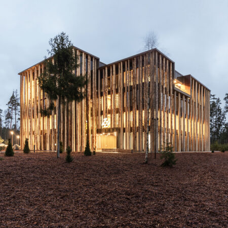 Baumstämme als Fassade an einem Holzbau