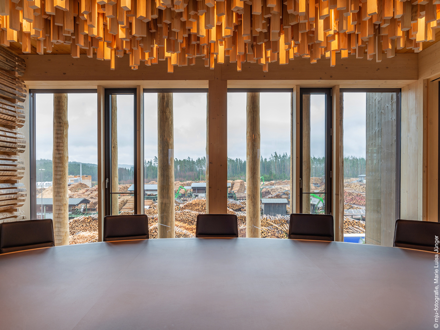 Baumstämme vor einem Konferenzraum in einem Holzbau