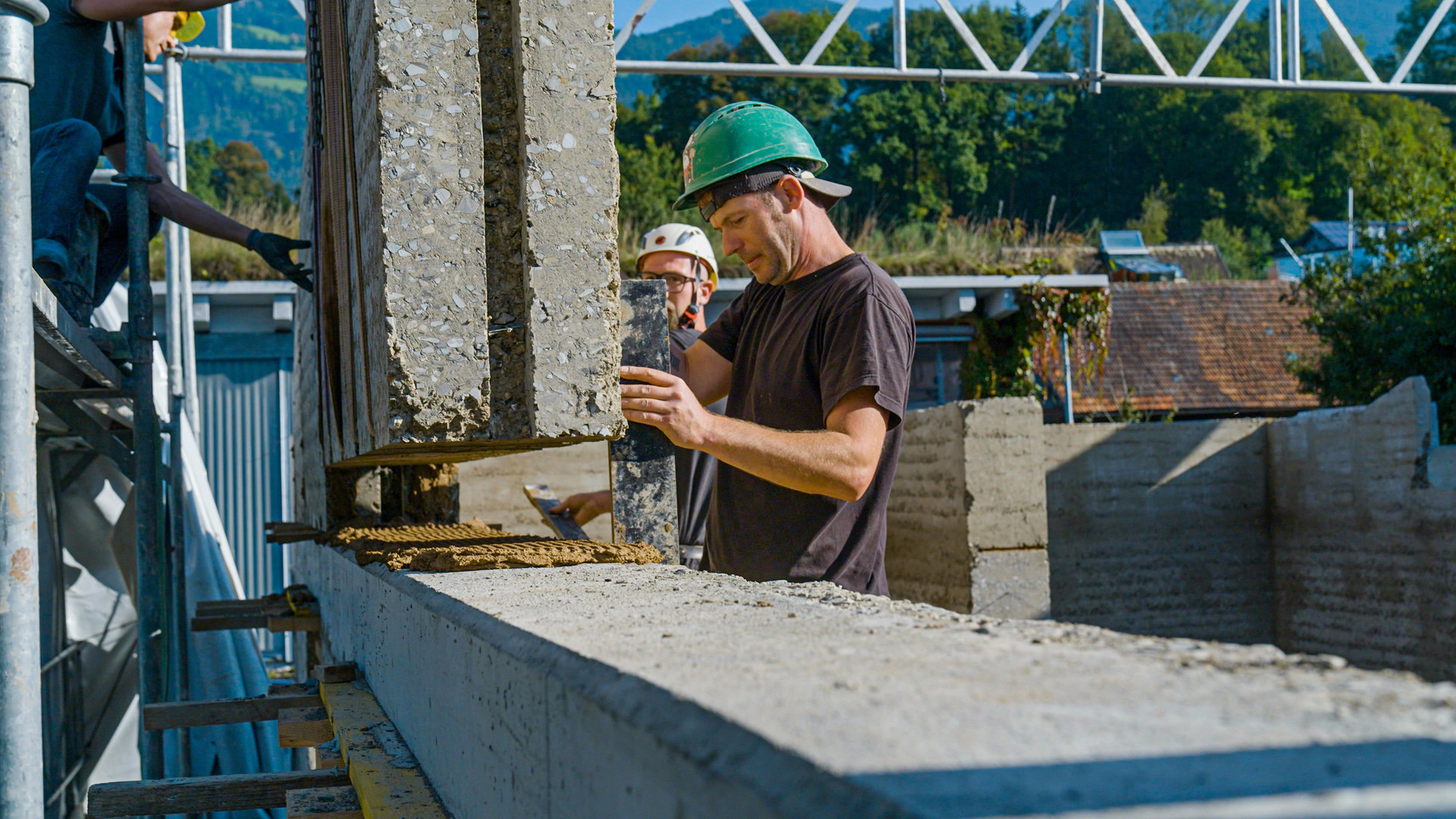 Bauarbeiter bei der Montage eienr Wand aus Lehm