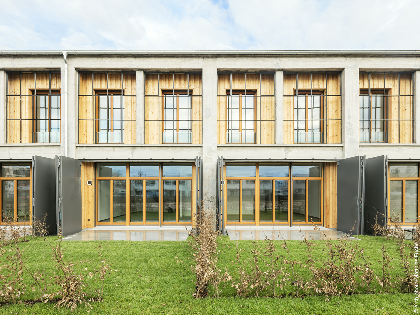 Wohnungen Fassade aus Holz und Beton mit Garten