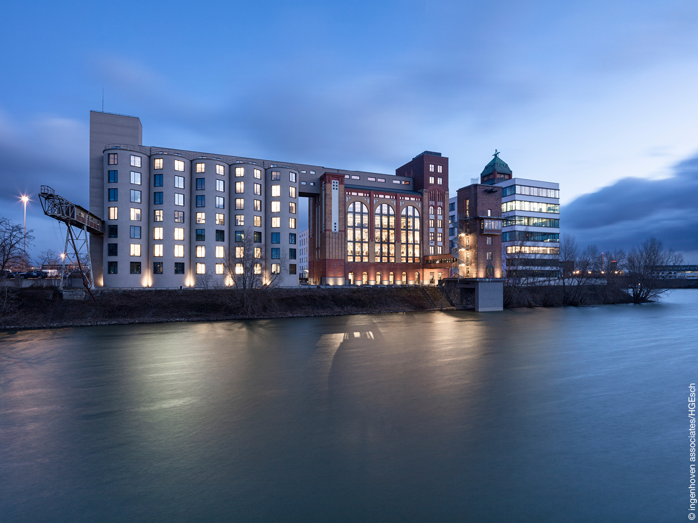Silo mit beleuchteten Fenstern an Hafenbecken in Düsseldorf