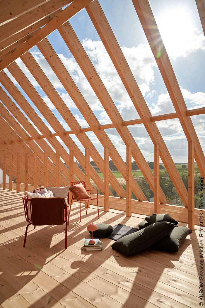 Offener Dachstuhl mit Holzbalken und Sitzkissen