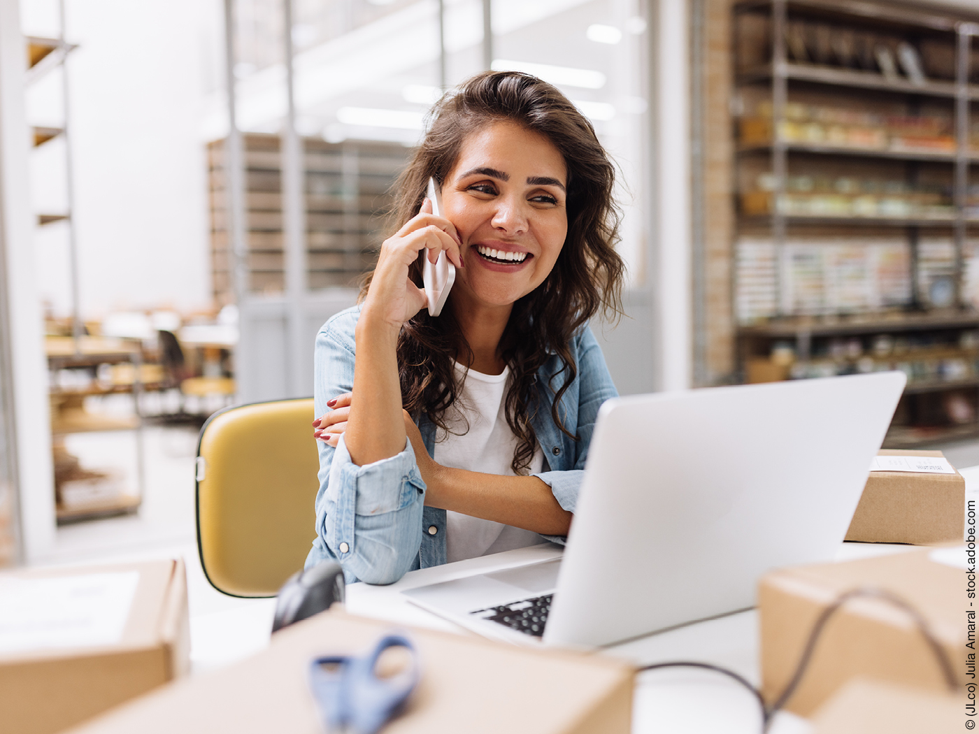 Telefonierende Frau vor Laptop