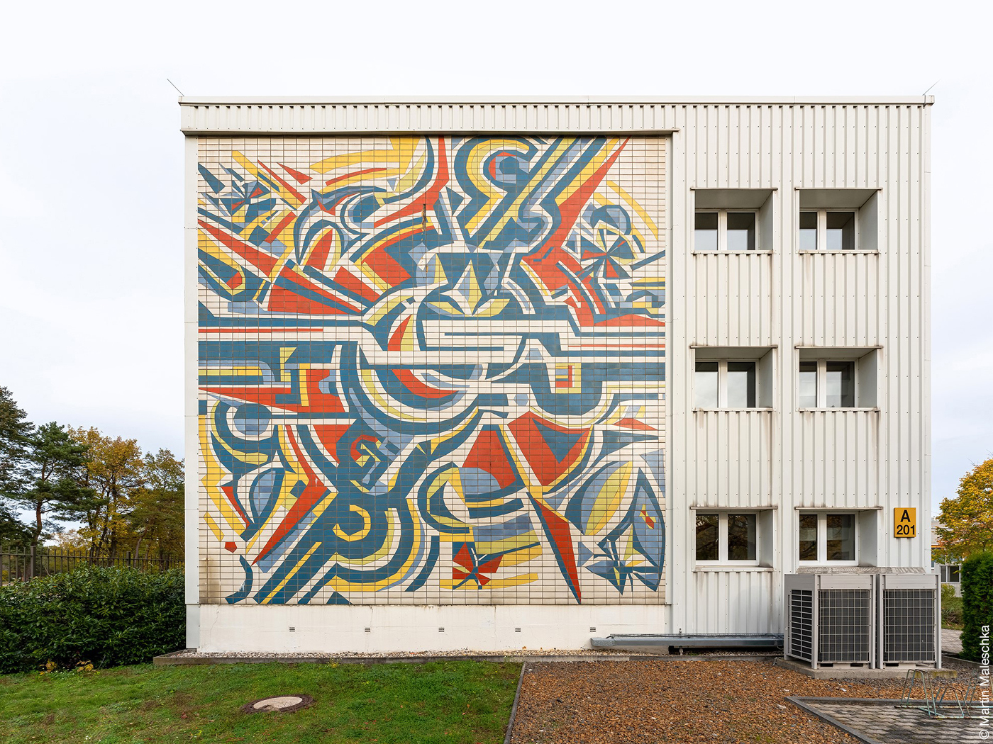 Industriegebäude mit farbigem Wandbild aus Fliesen