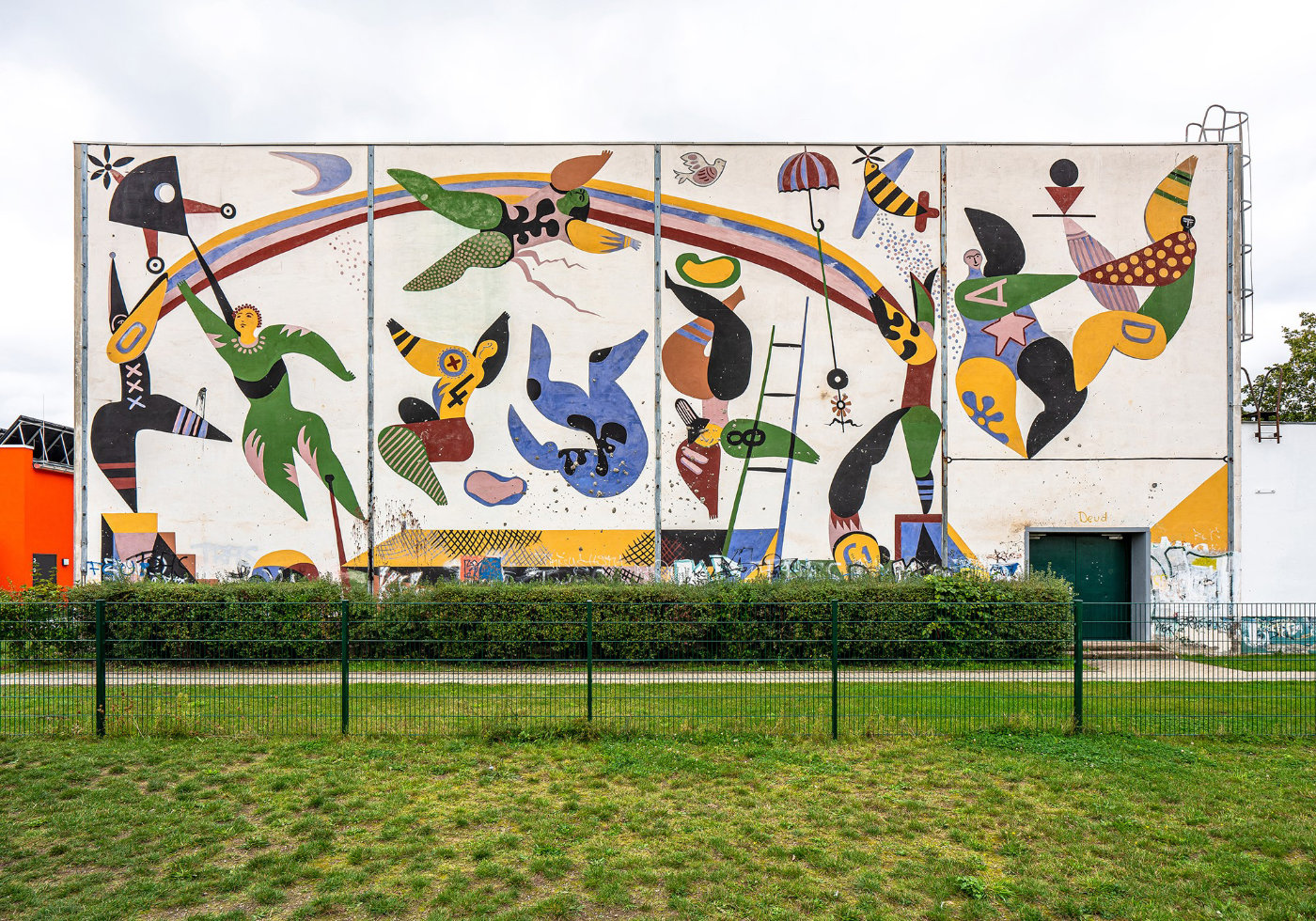 Bunte Wandmalerei mit Regenbogen und fliegenden Menschen