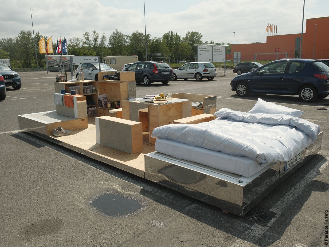 Parklet mit Bett und Möbeln auf einem Parkplatz