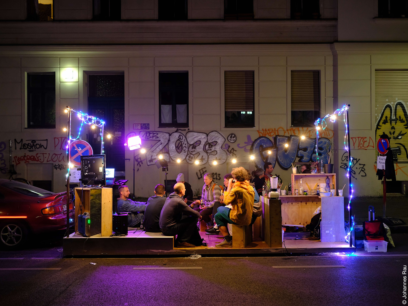 Party auf Parklet mit Lichterketten auf der Straße