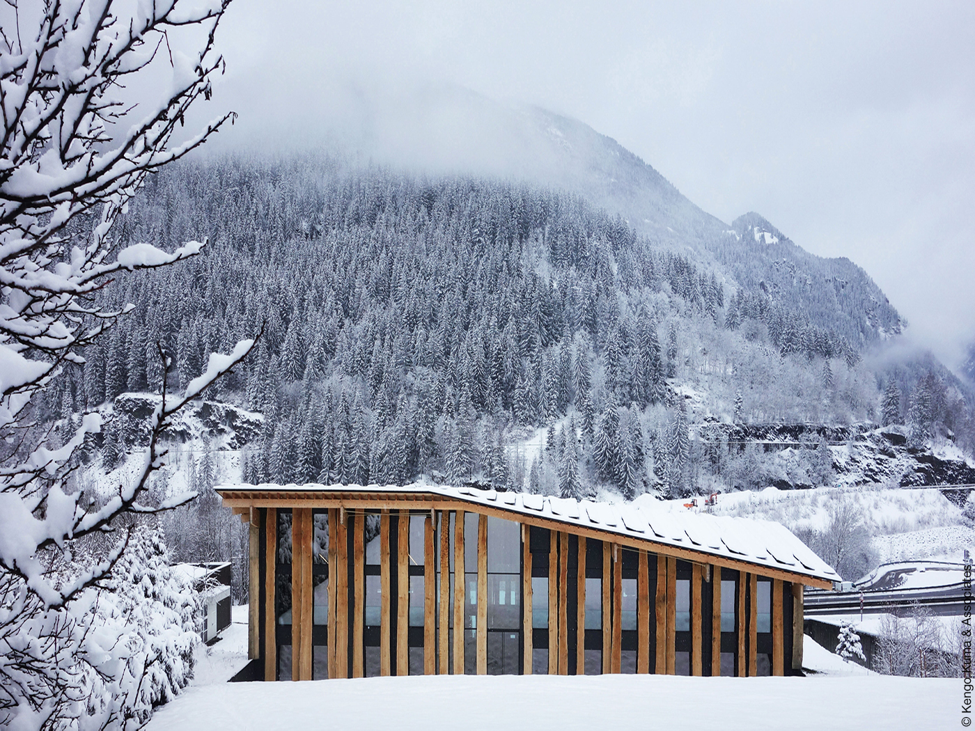 Haus mit Fassade aus Glas und Holz inmitten eines verschneiten Waldes