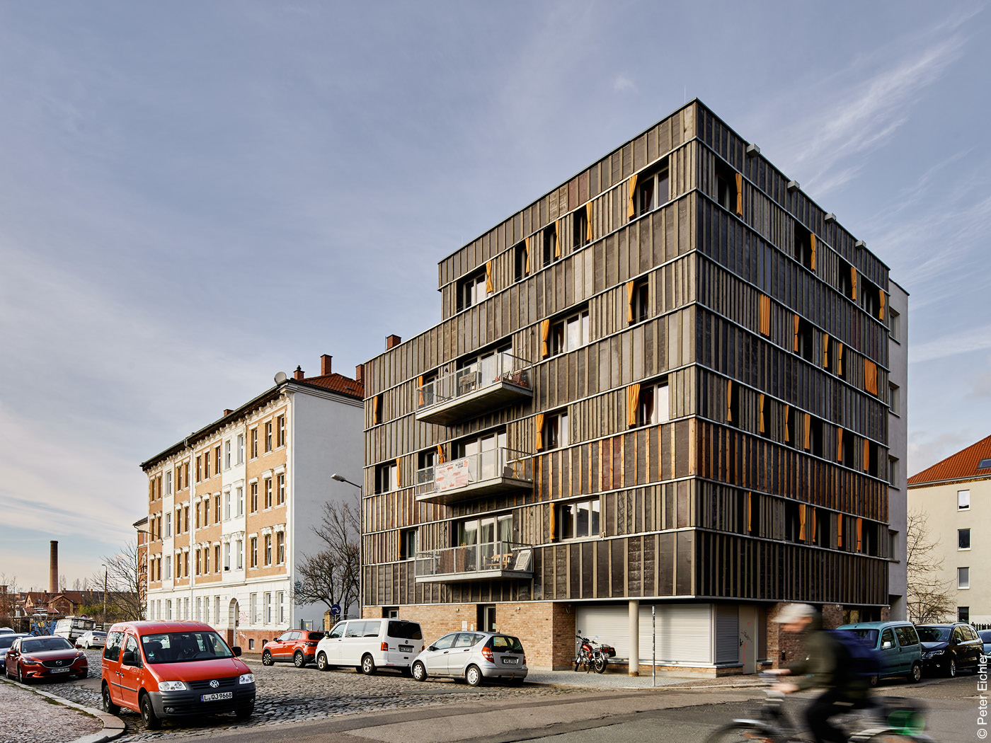 Neubau mit schwarzer Fassade und Holzlatten