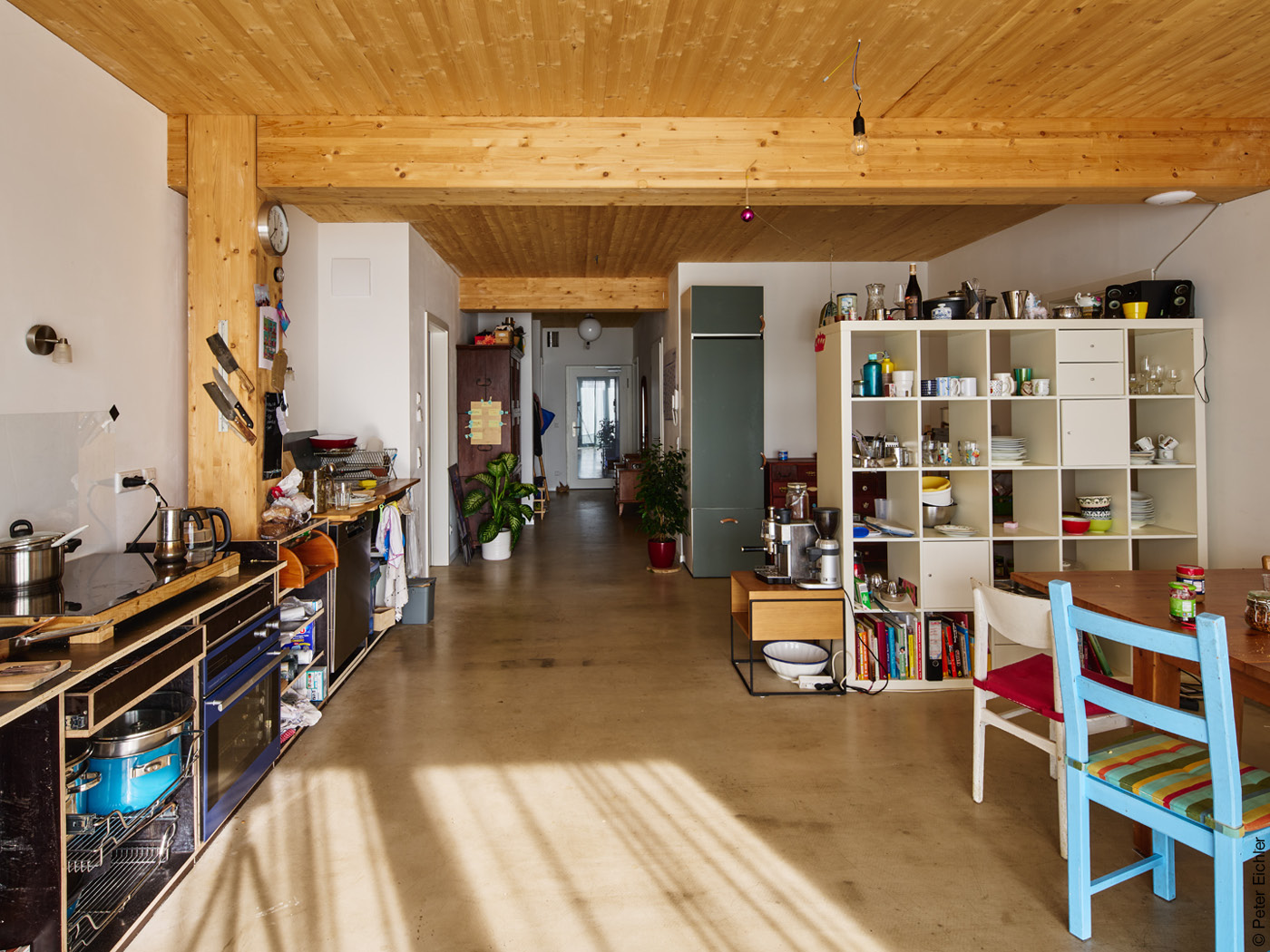 Wohnzimmer mit Küchenzeile, Estrichboden und Holzdecke