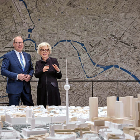 Mann und Frau stehen hinter Modellbau von Berlin