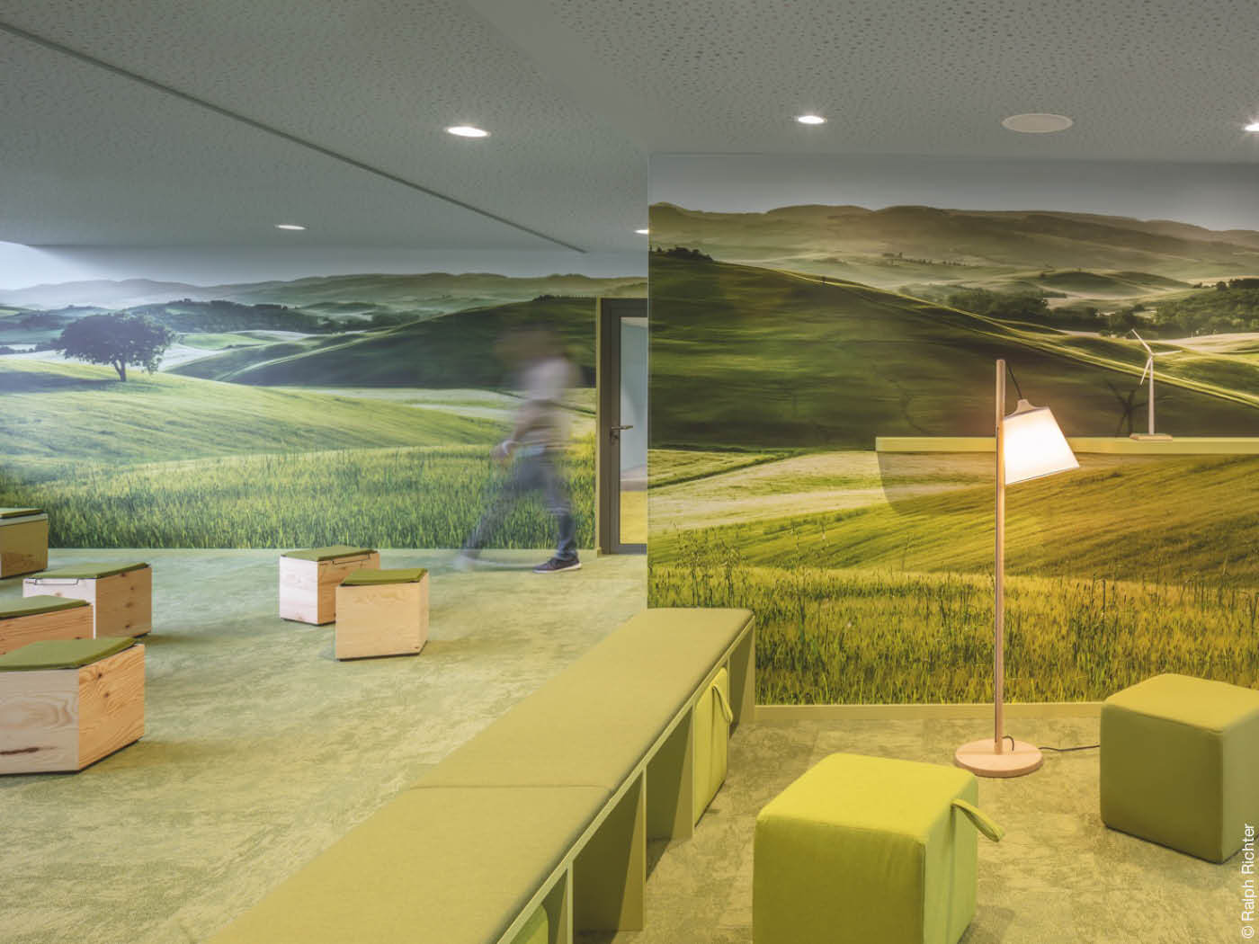 grüner Raum mit Sitzmöglichkeiten und Landschaftstapete