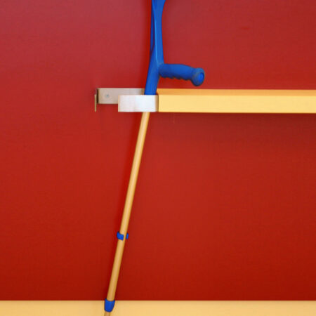 Krücke vor roter Wand