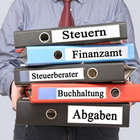 Mann mit Aktenordnern für Steuererklärung