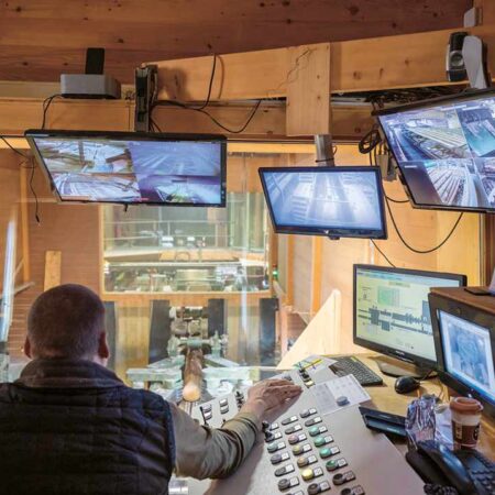 Kontrollraum mit Monitoren in Sägewerk